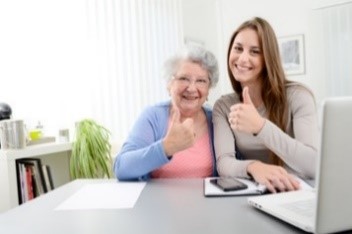 Image of older person and social care worker with thumbs up